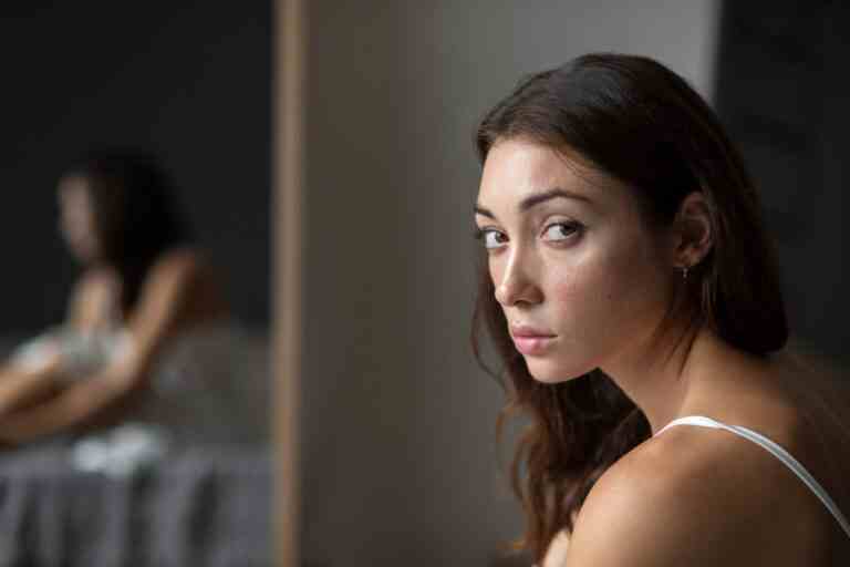 portrait young woman with low self esteem with mirror