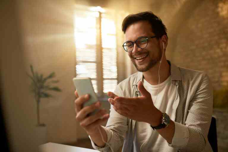 young happy businessman using mobile phone while working office