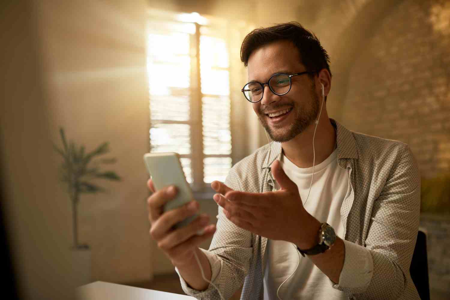 young happy businessman using mobile phone while working office