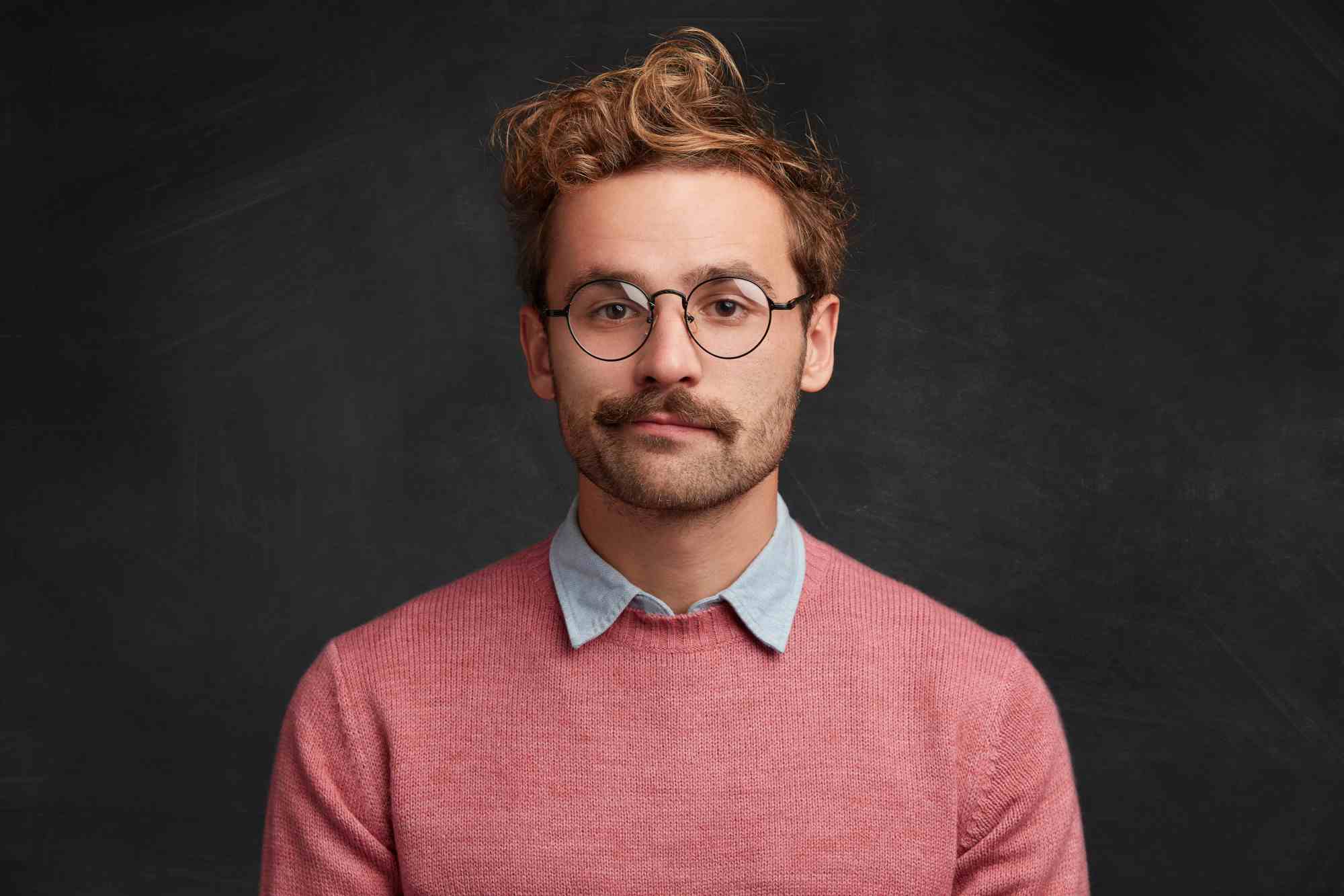 young man with beard round glasses