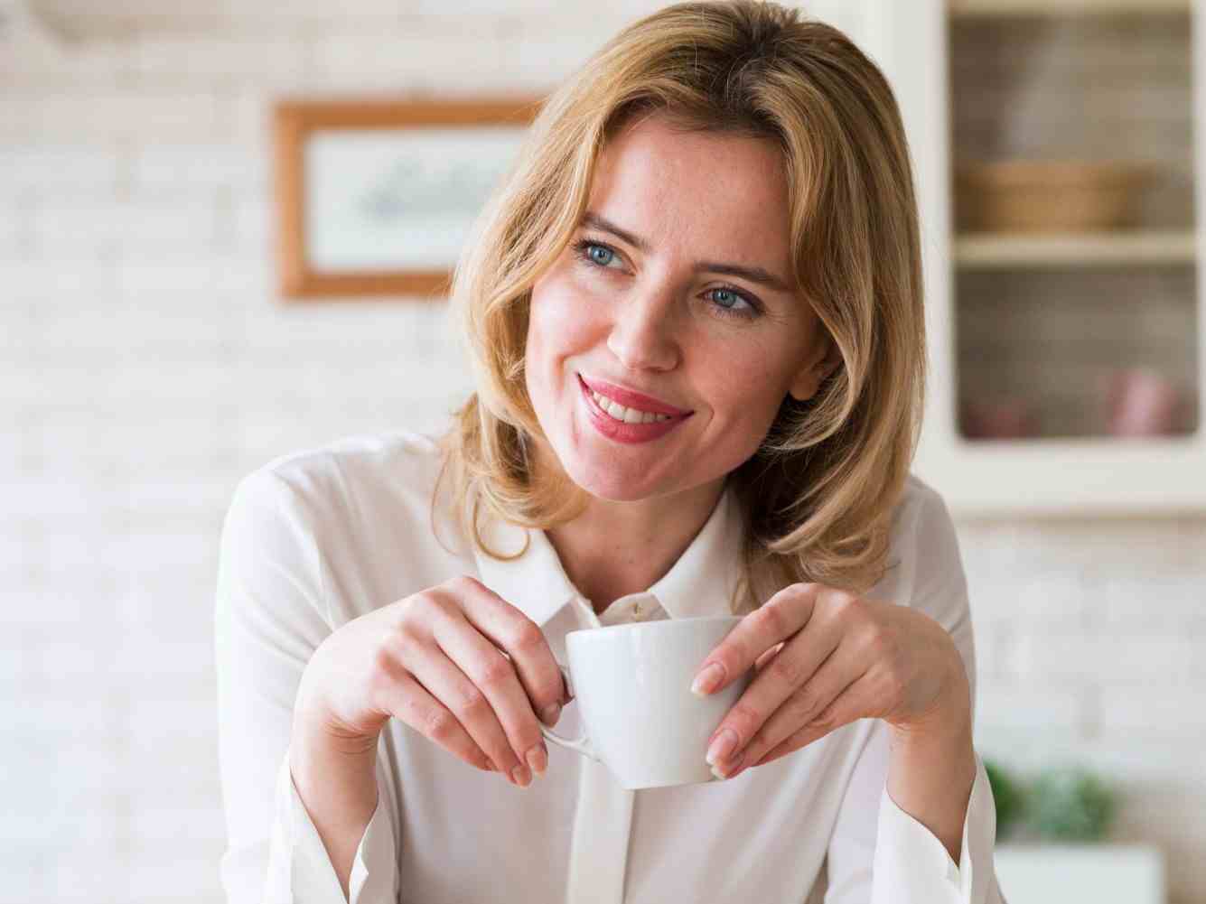 blond business woman sitting with coffee cup