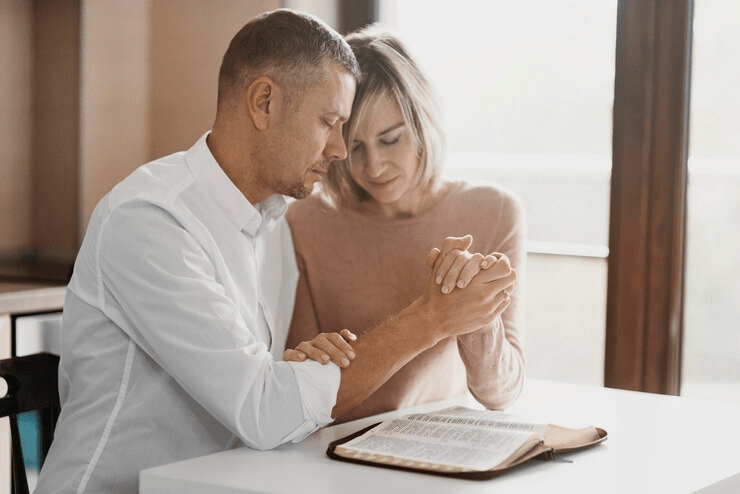 Pentecostal couple reading the bible and praying together 
