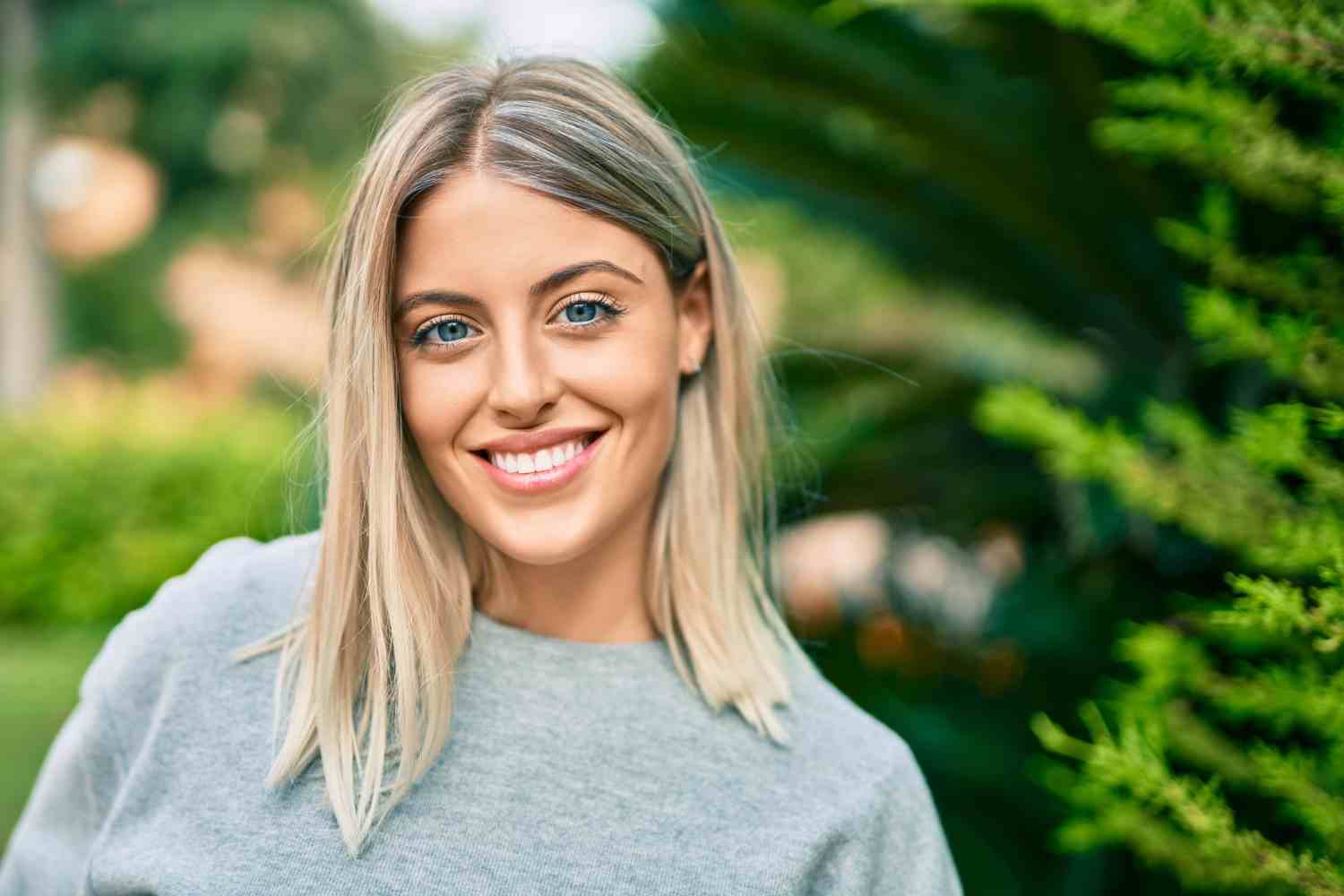 young blonde girl smiling happy standing park